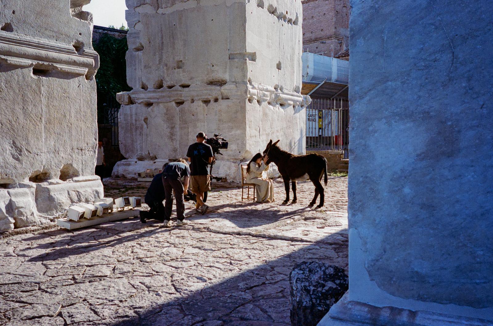 A wide view of the shoot framed between two ancient columns, monitors queued along the stone floor